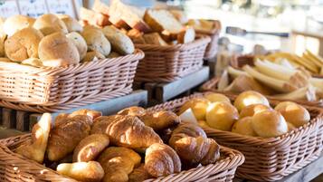 Baskets of various baked goods, including bread and rolls, displayed in a bakery setting.