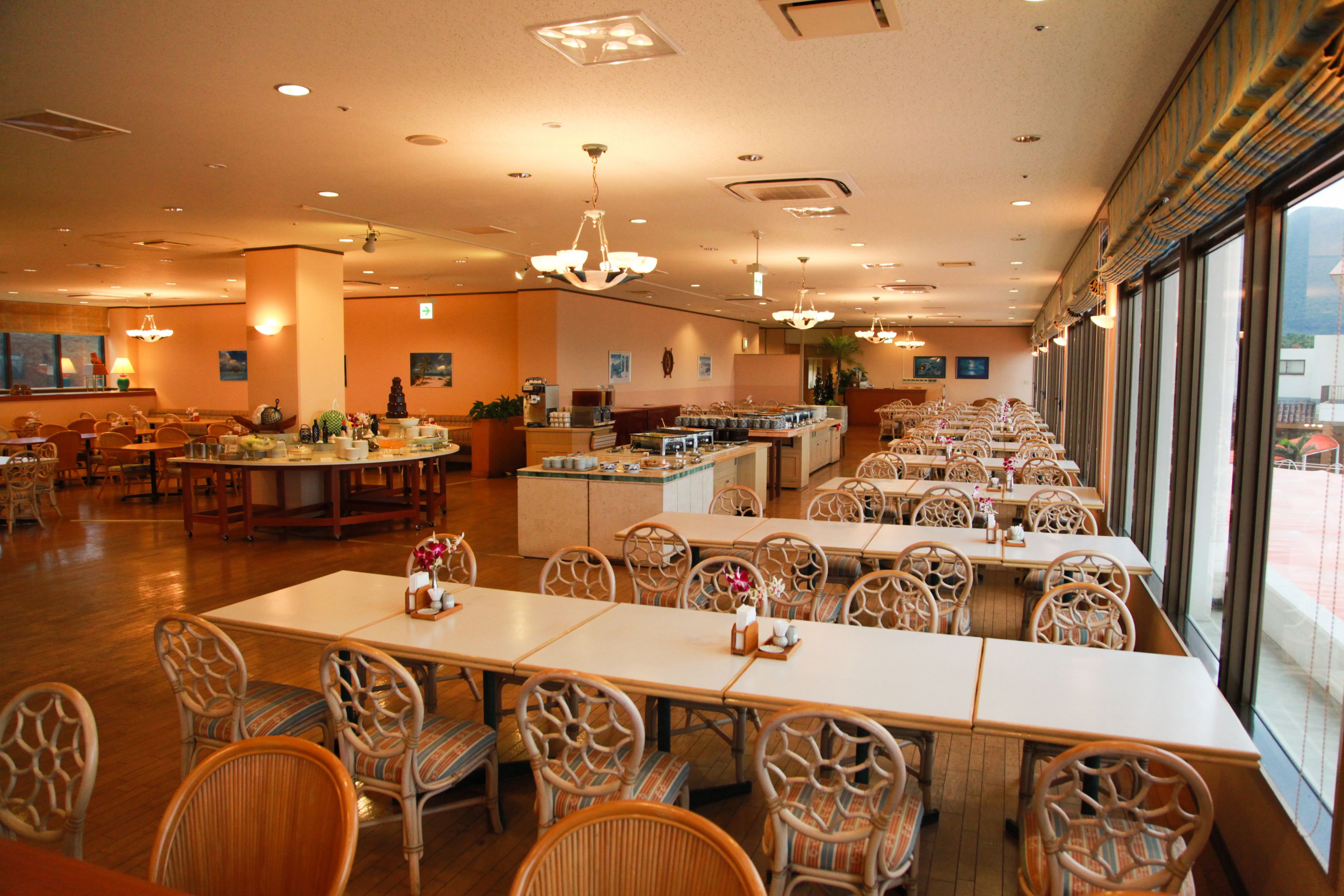 A spacious restaurant with high ceilings, multiple dining areas, and large windows offering views.
