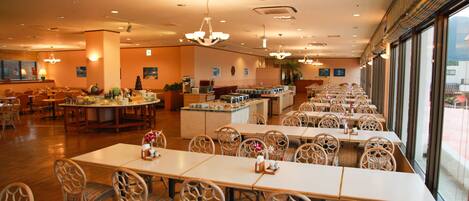 A spacious restaurant with high ceilings, multiple dining areas, and large windows offering views.