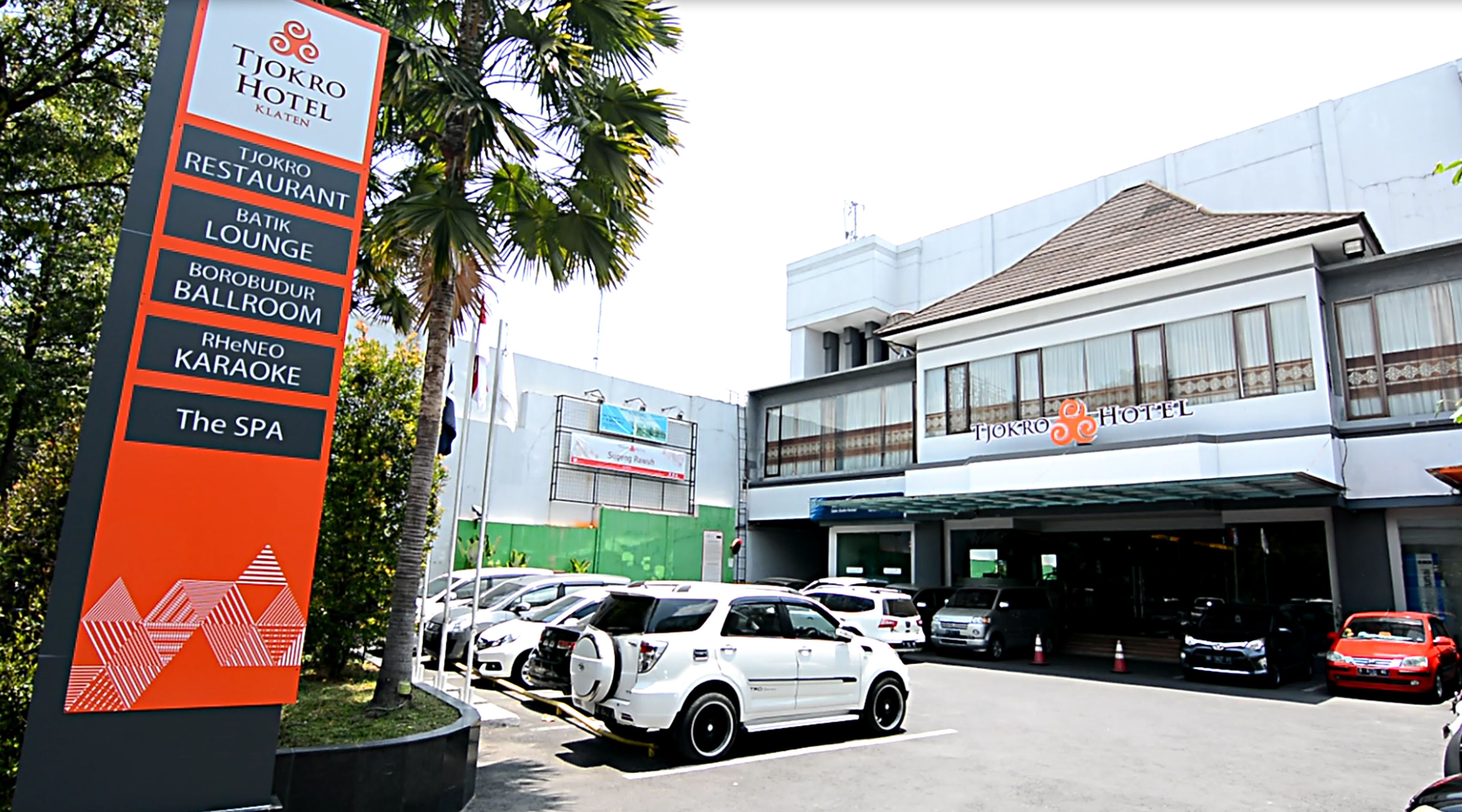 Un letrero de hotel que enumera servicios como restaurante, sala de estar, karaoke y spa.