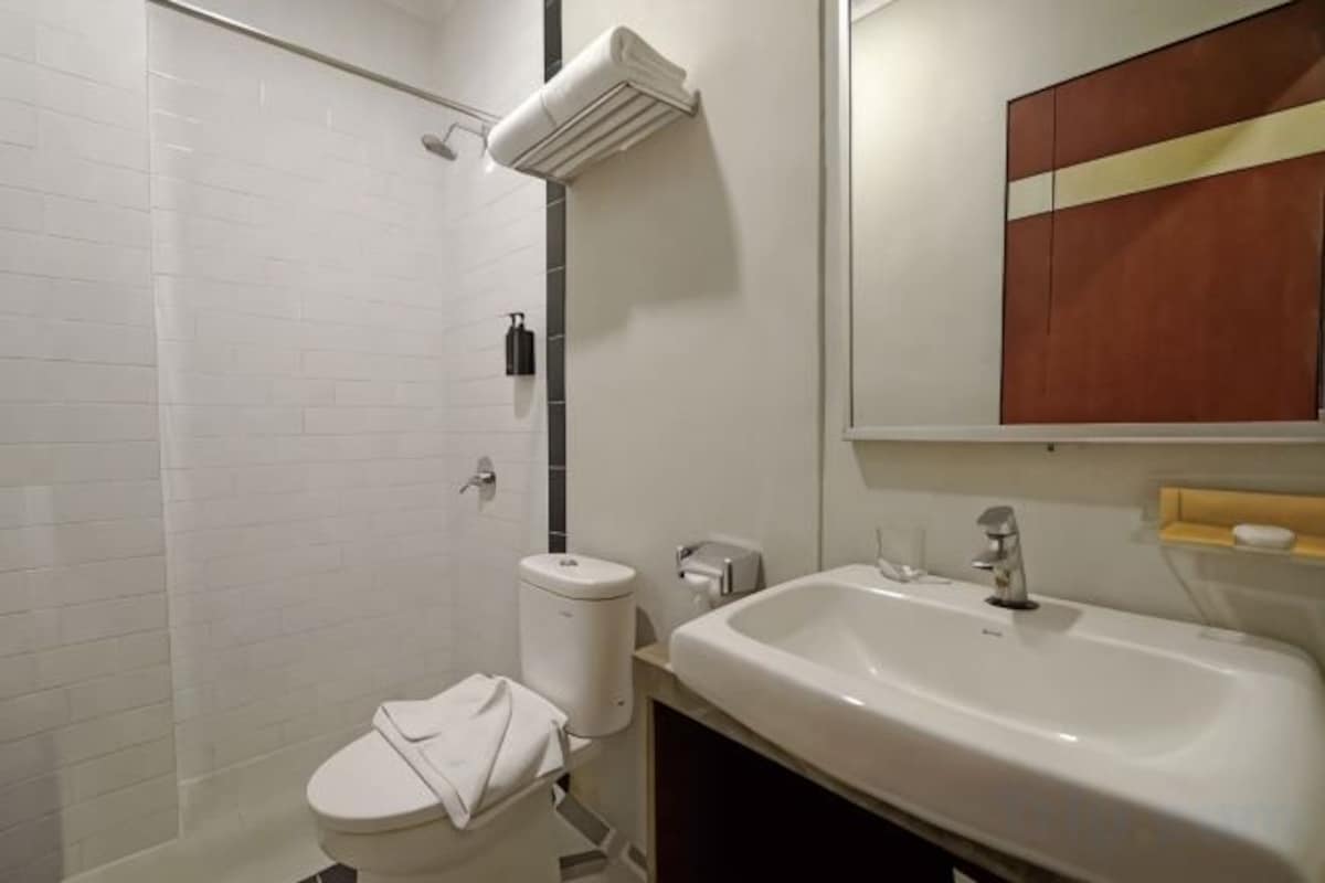 Un baño con inodoro, lavabo y ducha.
