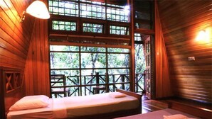 A wooden cabin room with two beds, a window with a view of trees, and a wooden railing outside. - Tabin Wildlife Resort (Lahad Datu)