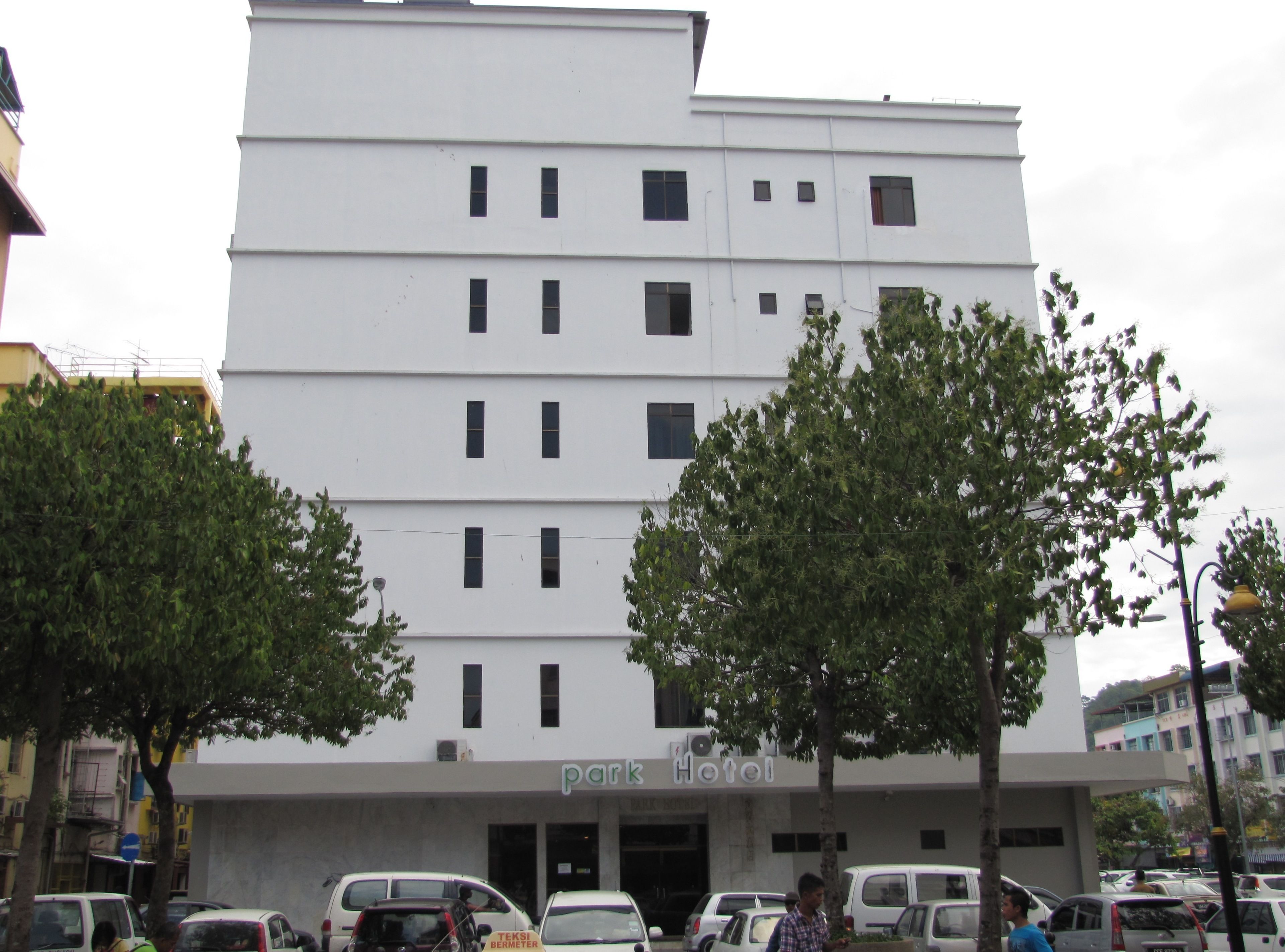 A multi-story building with a flat facade, several windows, and a sign reading "park hotel".