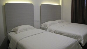 A hotel room with two single beds, each with a headboard and a white bedspread. - Park Hotel (Kota Kinabalu)