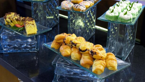 A display of various pastries on glass stands. - Oak Tree Emerald Hotel & Conventions Semarang (Semarang)