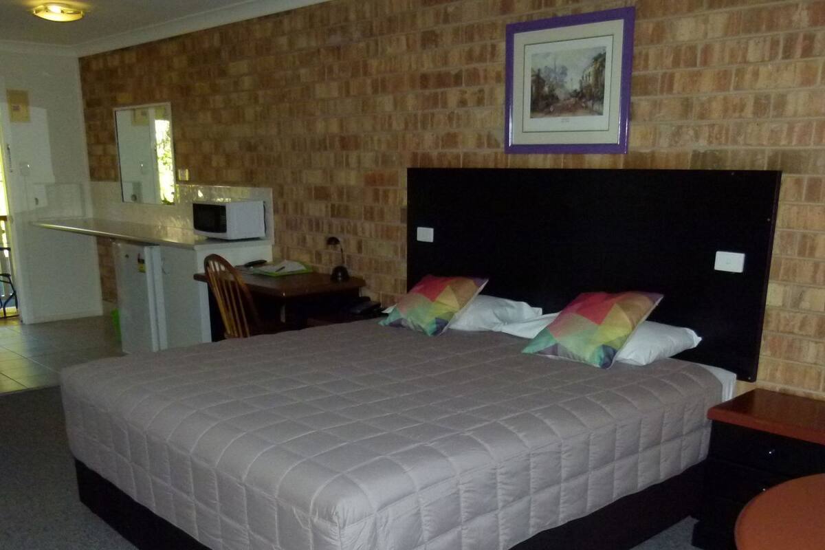 Una habitación de hotel con una cama grande, un escritorio y una silla.