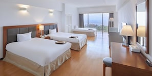 A hotel room with two beds, a desk, a chair, and a large window with a view. - Hotel Mahaina Wellness Resort Okinawa (Motobu)