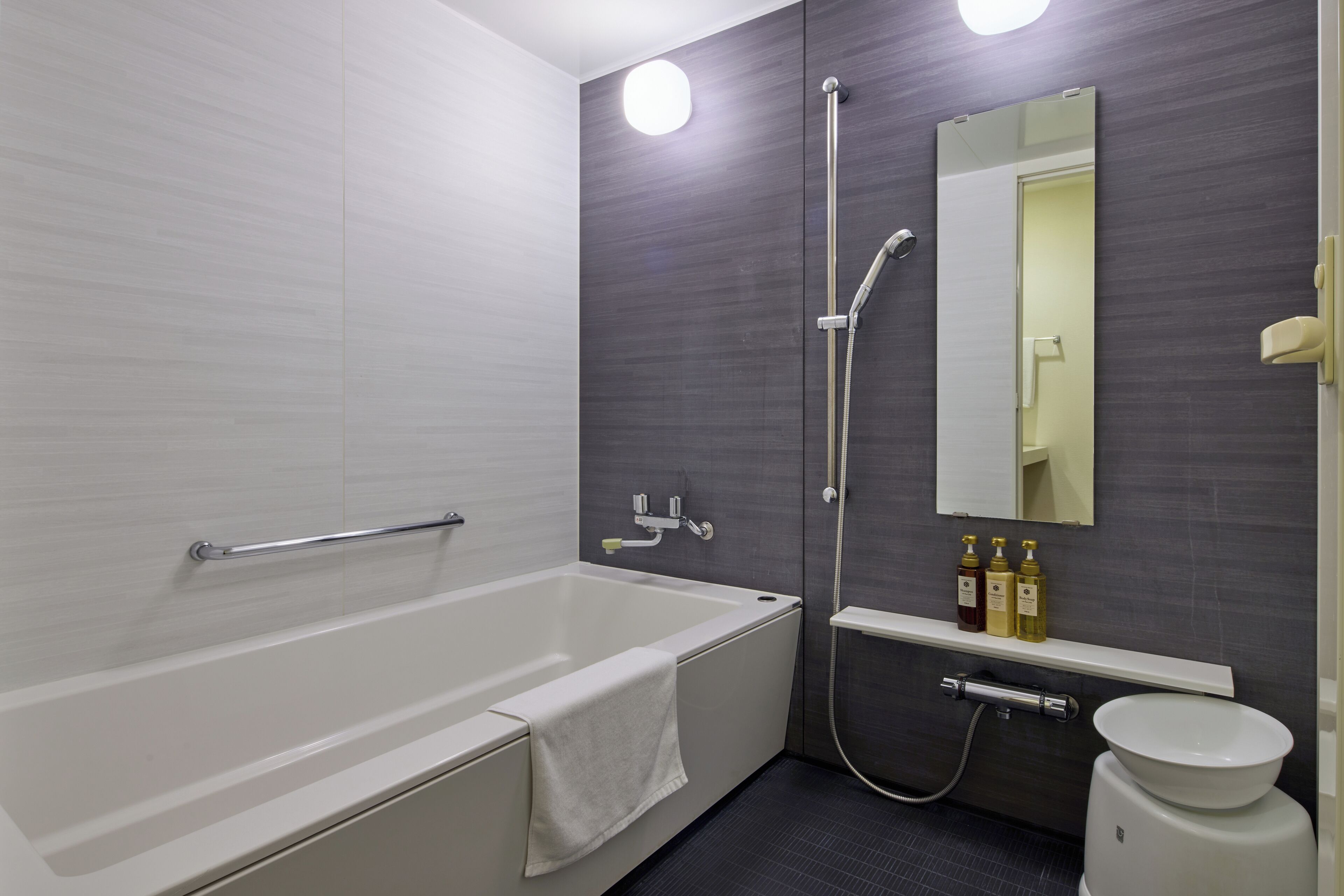 Ein modernes Badezimmer mit Badewanne, Dusche, Toilette und Spiegel.