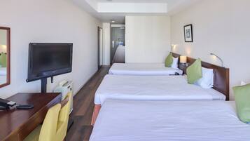 Habitación de hotel con dos camas, un televisor, un escritorio con teléfono y una silla.