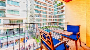 A balcony with a table and chairs, overlooking a multi-story building with balconies. - High Lords Residence (Pattaya)