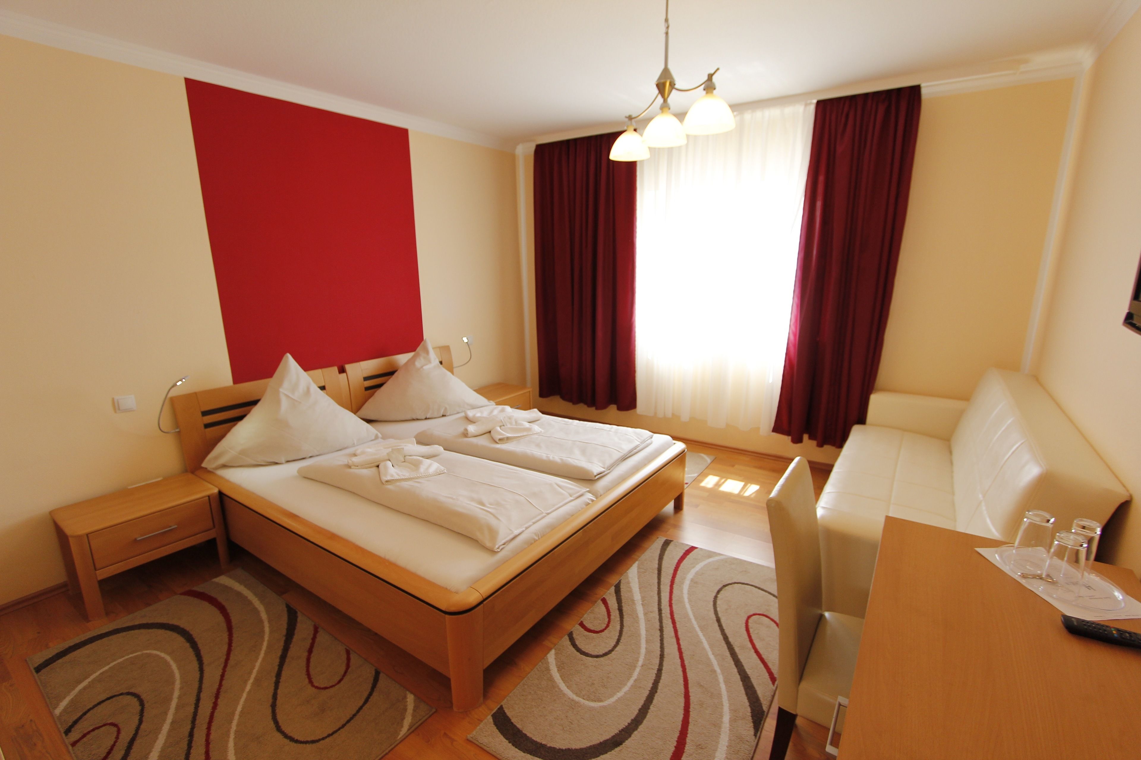 Une chambre d’hôtel comprenant un lit, des tables de chevet, un bureau et un canapé.