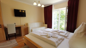 A hotel room with a bed, a desk, a chair, a TV, and a window with curtains. - Hotel Rhein-Mosel-View (Urbar)