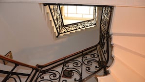 A staircase with ornate black metal railings and a small window at the top. - Hotel New Milan (Milan)