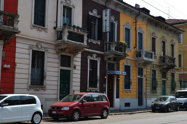 A building with a sign reading "HOTEL NEW MILAN" and balconies with potted plants. - Hotel New Milan (Milan)