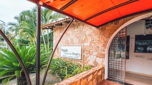 A stone-walled building with a sign reading "Pousada Casa de Pedra." - VELINN Pousada Casa de Pedra Ilhabela (Ilhabela)