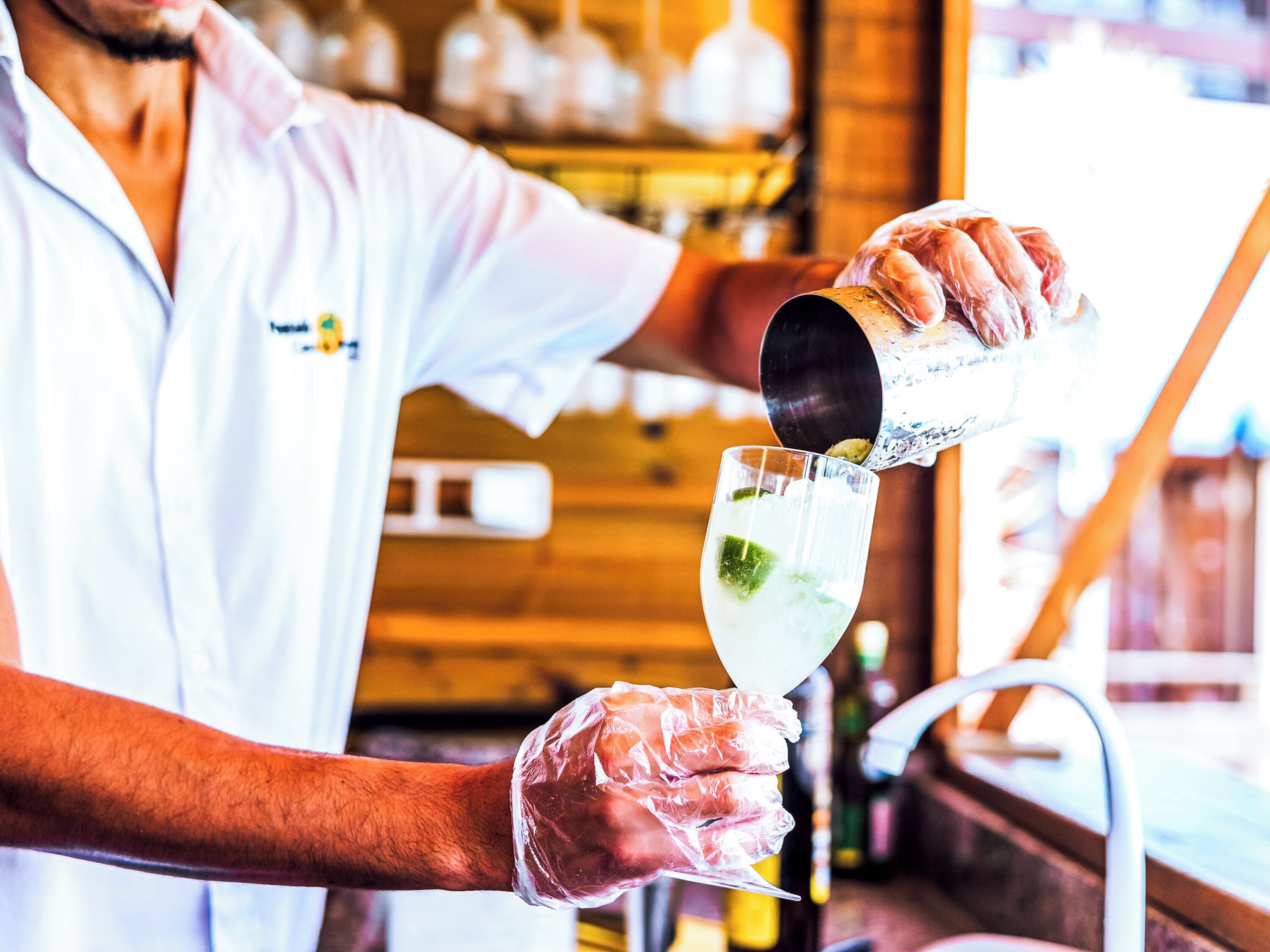 Um bartender a servir uma bebida num copo.