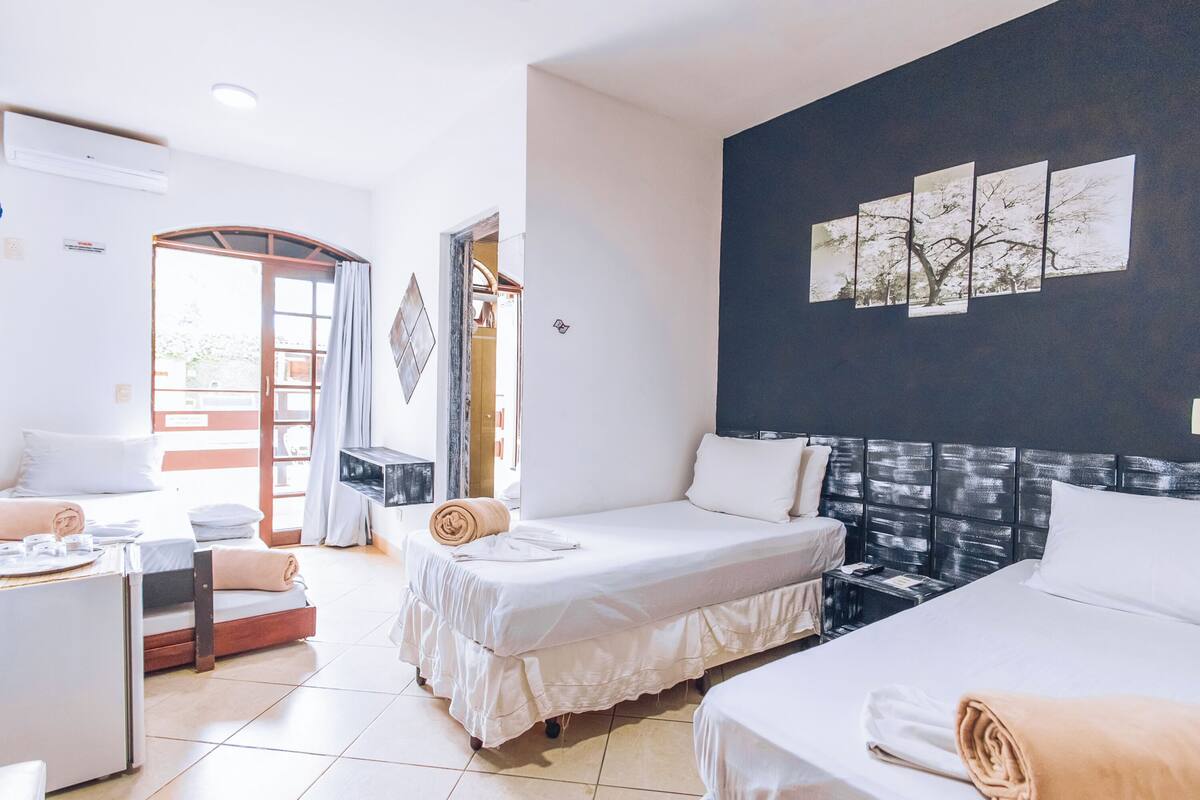 Ein Hotelzimmer mit zwei Betten, einem Schreibtisch und einem großen Fenster.
