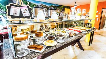 Un mostrador de buffet con una variedad de postres y bebidas.