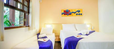 Habitación de hotel con dos camas, ventana con persianas, un cuadro en la pared y un ventilador de techo.