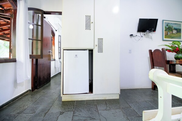 Relax in this cozy space with a comfortable chair, a mounted TV, and a convenient refrigerator.