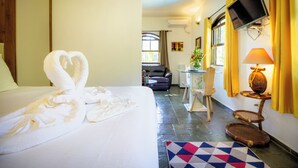 Ein Hotelzimmer mit Bett, Fernseher, Schreibtisch, Stuhl und Fenster.