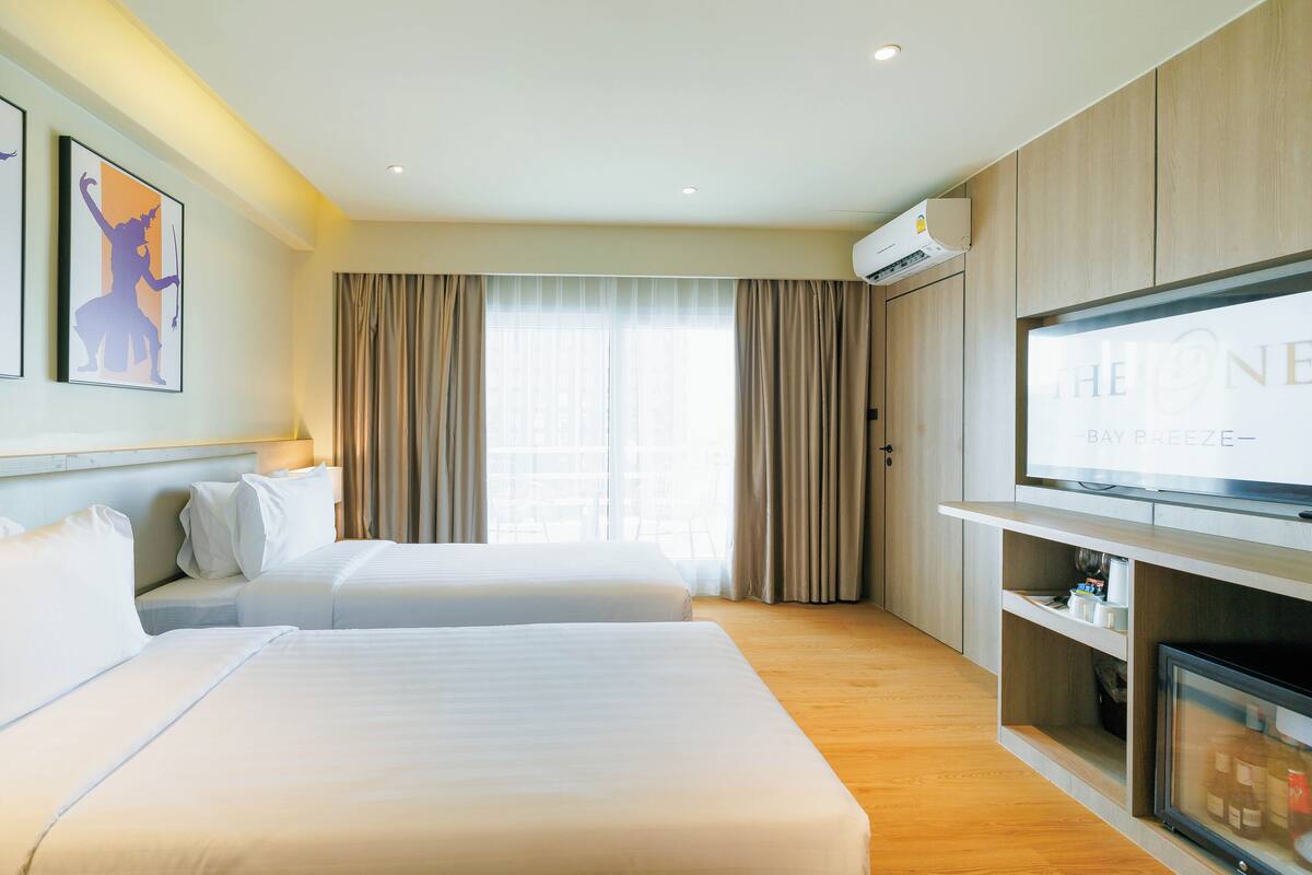 Une chambre d’hôtel avec deux lits, une télévision et un minibar.