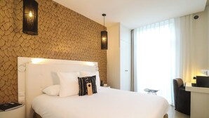 Een hotelkamer met een groot bed, een bureau en een stoel.