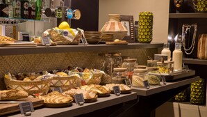 Een bakkerijvitrine met verschillende broden en gebak.