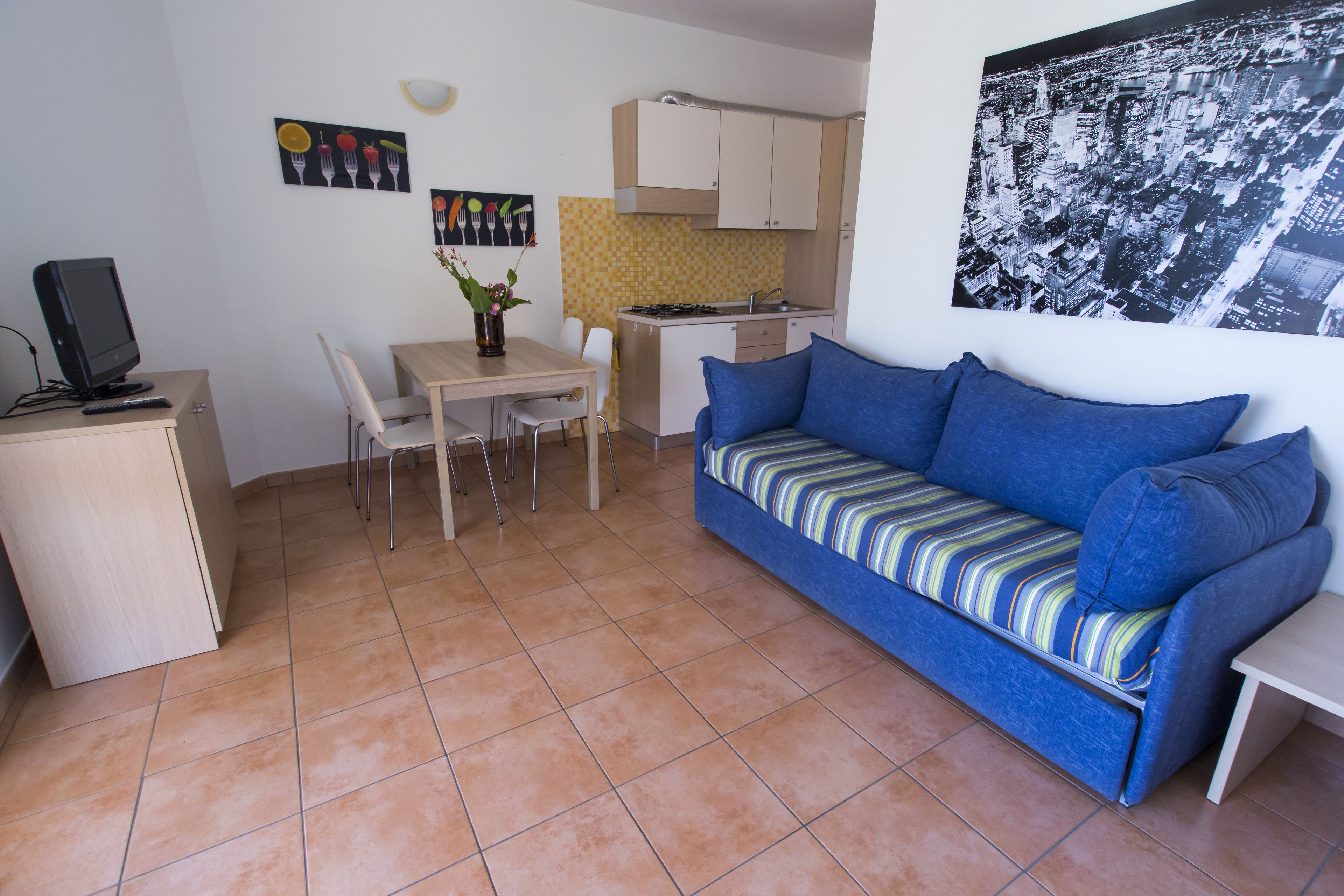 A compact living space with a kitchenette, a dining area, and a sofa.