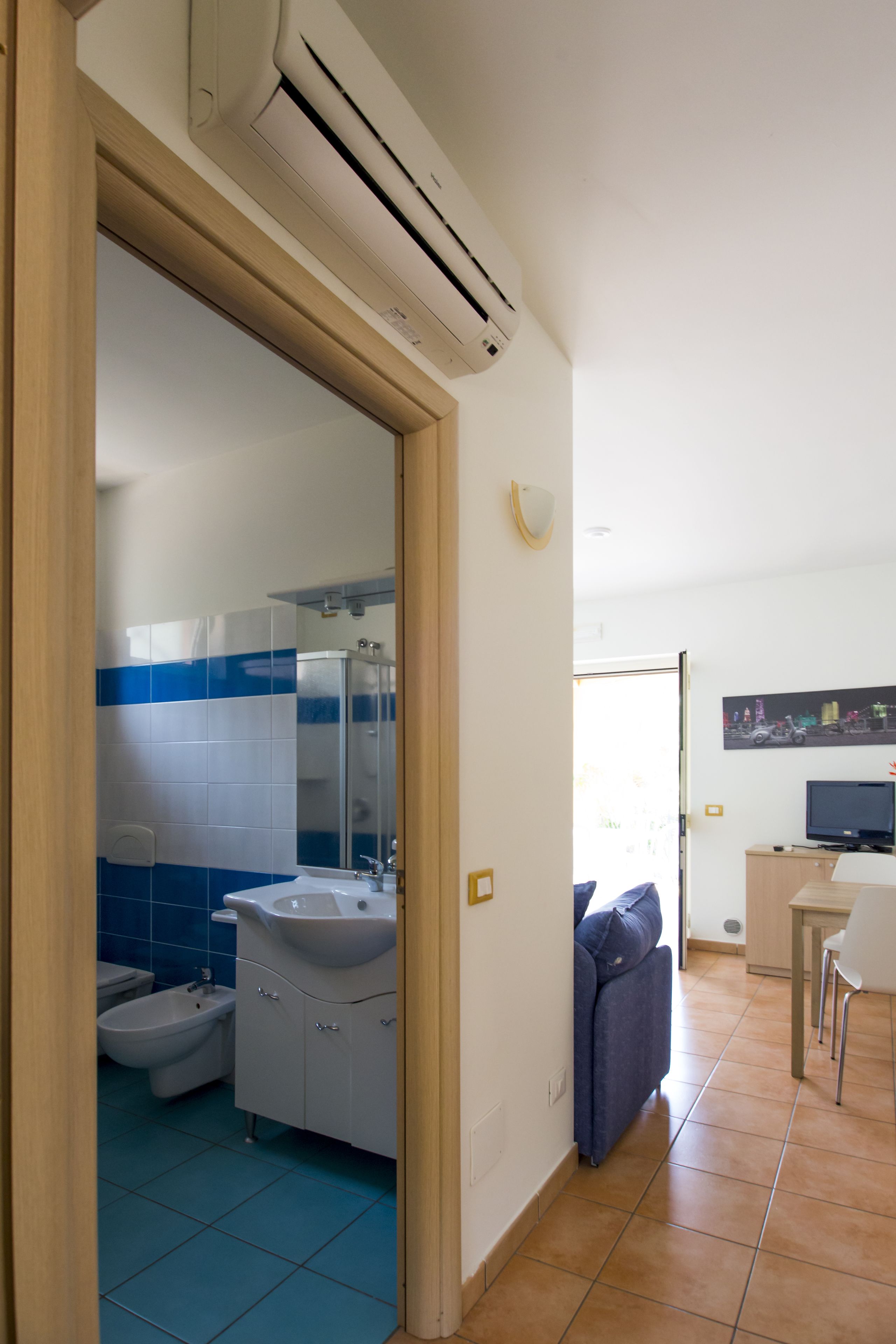 Un bagno moderno con un lavandino bianco, piastrelle blu e una doccia.