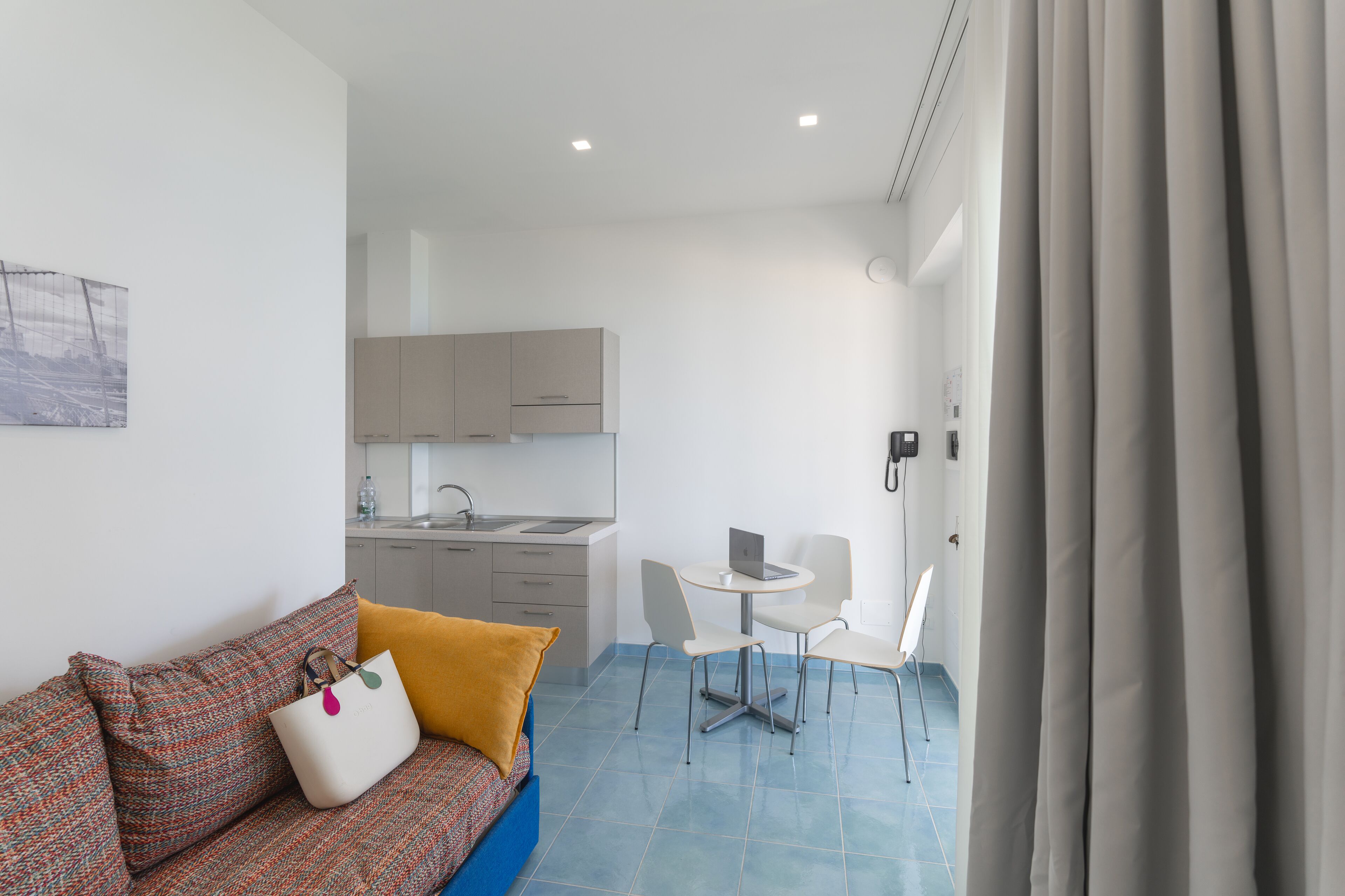 Un espace de vie compact comprenant un canapé, une petite table à manger et une kitchenette.