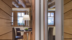 Un intérieur en bois comprenant un coin repas, une lampe et une vue par une fenêtre.