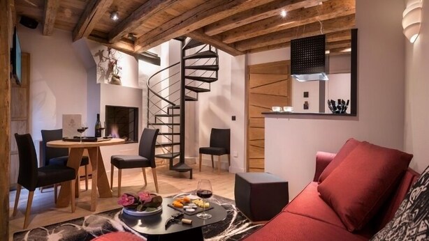 Un salon moderne avec un escalier en colimaçon, un coin repas et une cuisine.