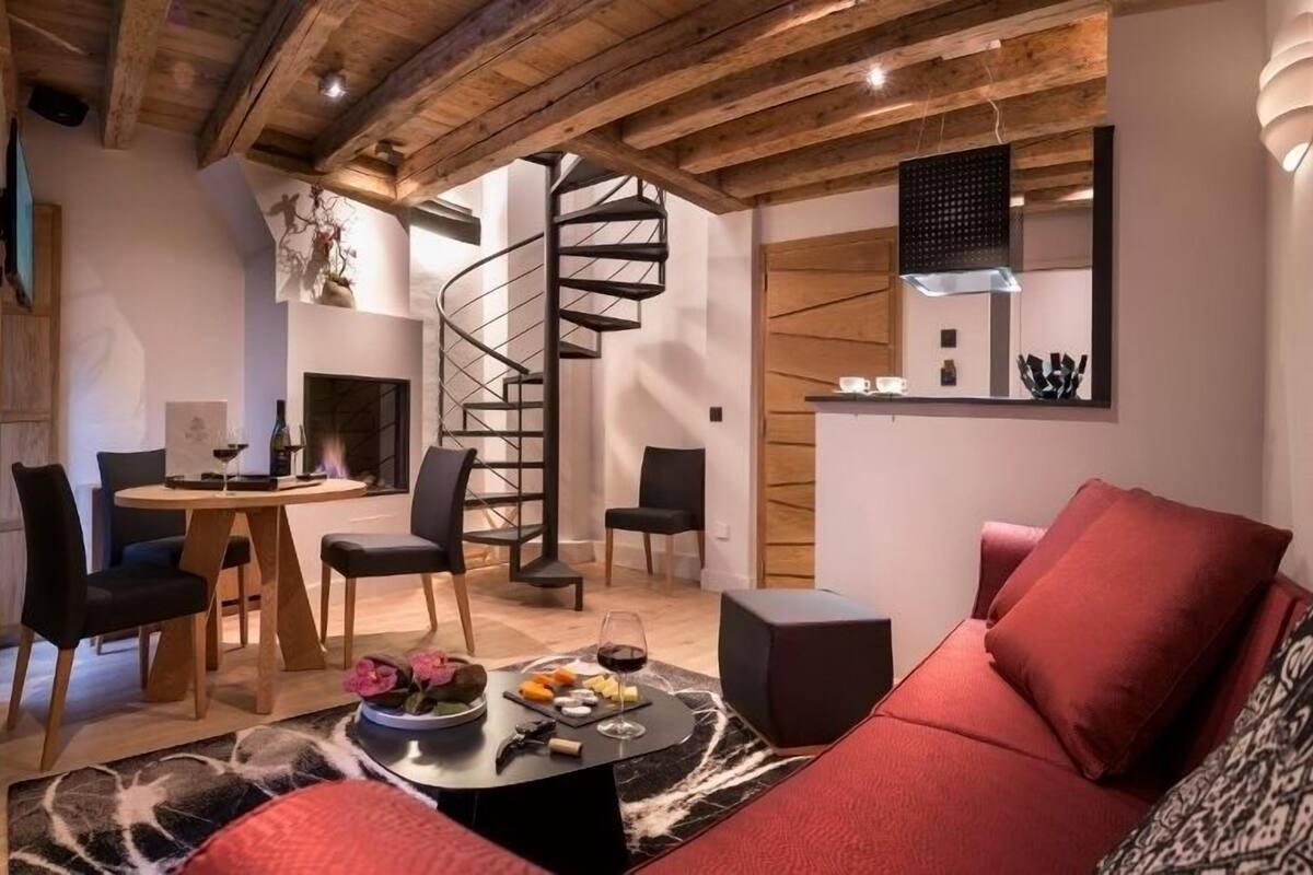Un salon moderne avec un escalier en colimaçon, un coin repas et une cuisine.