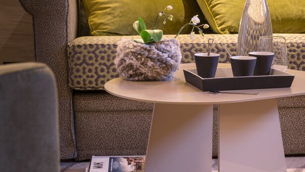 Ein modernes Wohnzimmer mit einer Couch, einem Couchtisch und Dekorationselementen.