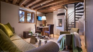 Un salon chaleureux avec une cheminée, un coin repas et un escalier menant à un autre niveau.