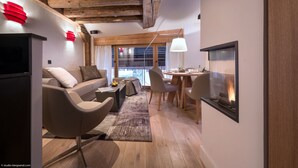 Un salon moderne comprenant un canapé, des fauteuils, une table basse, une cheminée et un coin repas.