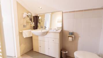 Ein Badezimmer mit Waschbecken, Spiegel, Handtuchhalter und Toilette.