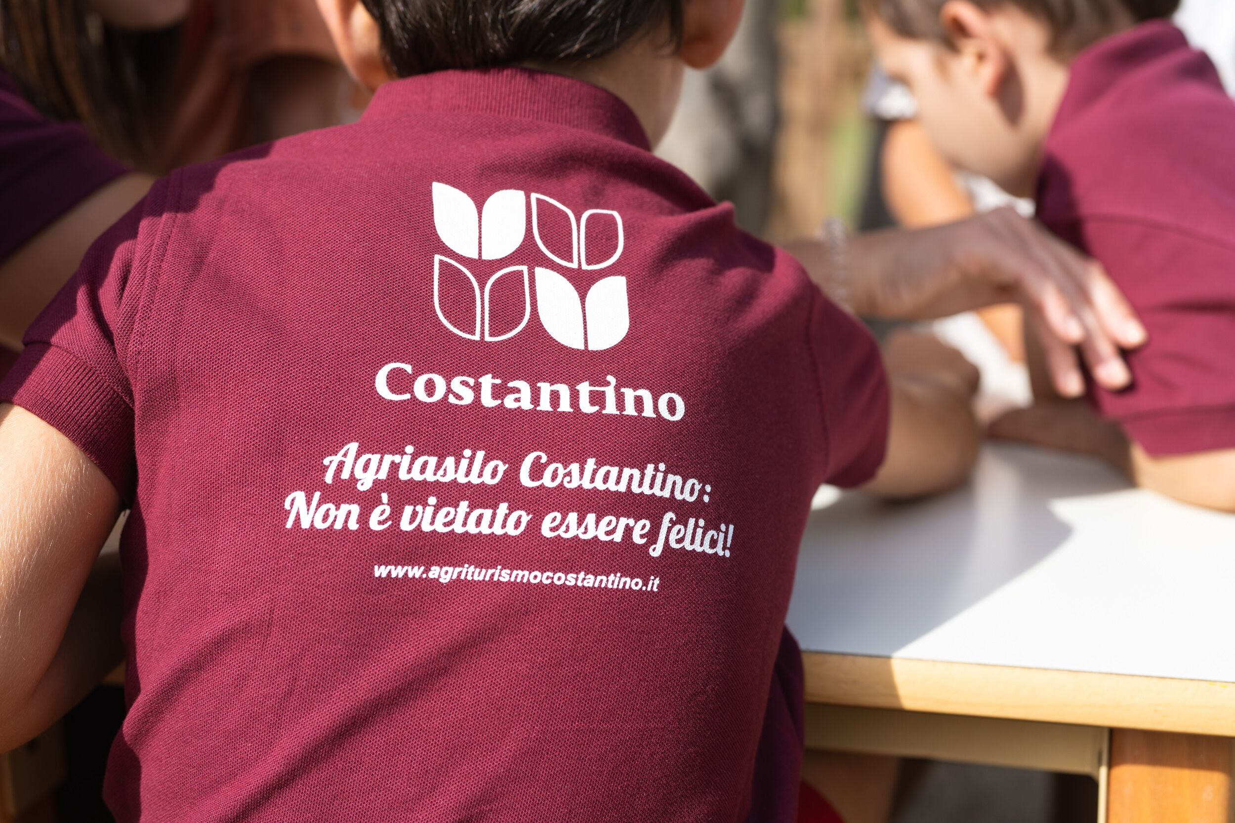 Una persona portant una camisa color terrissa amb un logotip i text al darrere.