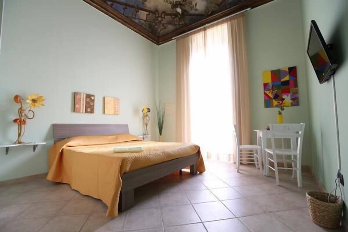 A bedroom with a bed, a desk, and a chair.