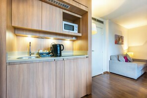 A kitchenette with a microwave, coffee maker, and sink. - City Residence Paris CDG Airport (Roissy-en-France)