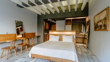 Un dormitorio moderno con una cama grande, escritorio de madera y armario empotrado.