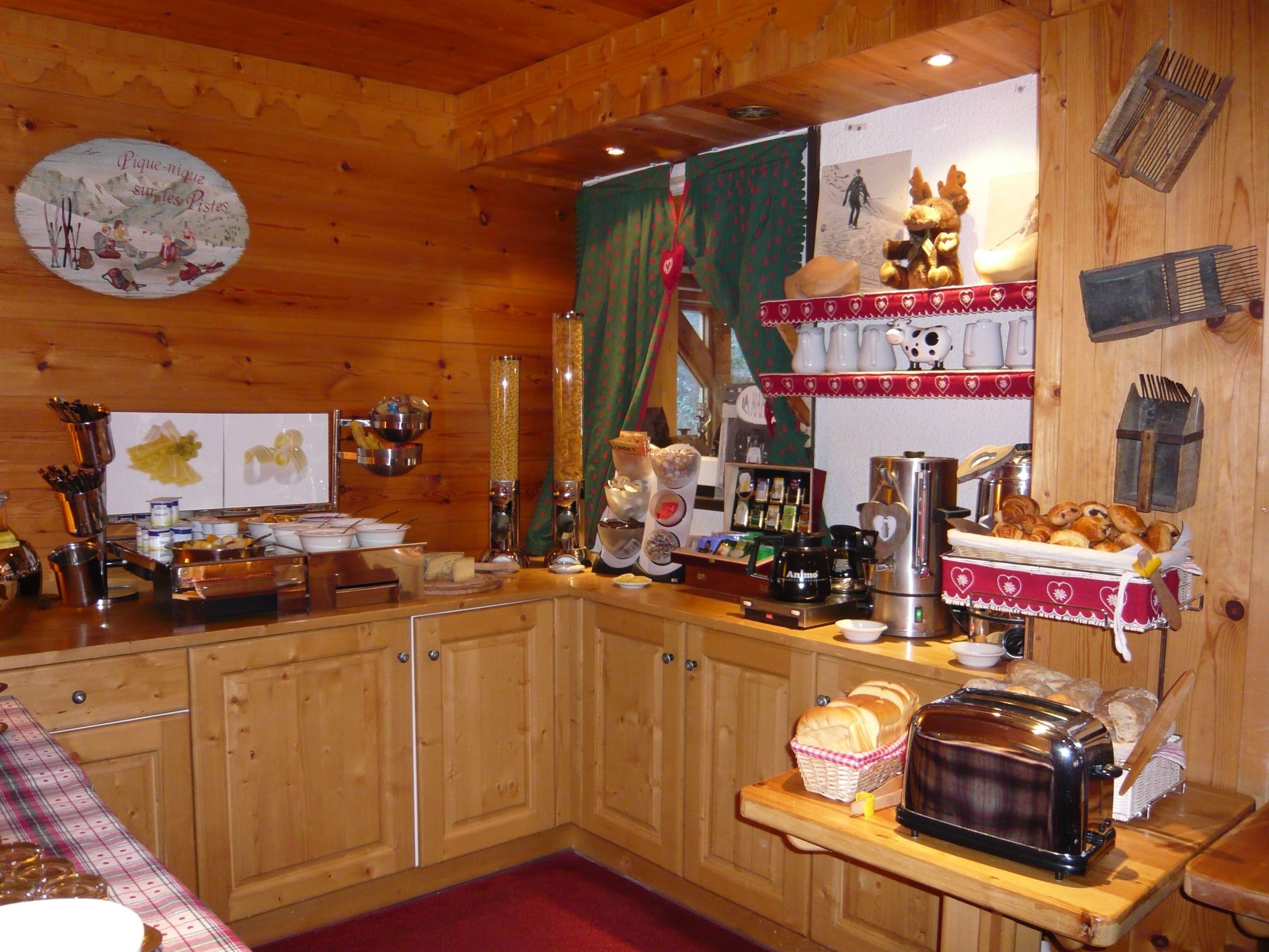 Cocina de cabaña de madera con mostrador de madera, varios electrodomésticos y decoración rústica.