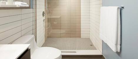 Un baño moderno con inodoro, ducha y toallero.