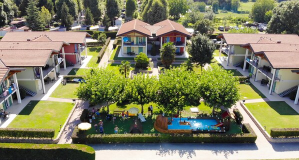 A residential complex with multiple houses, a swimming pool, and a well-maintained garden.