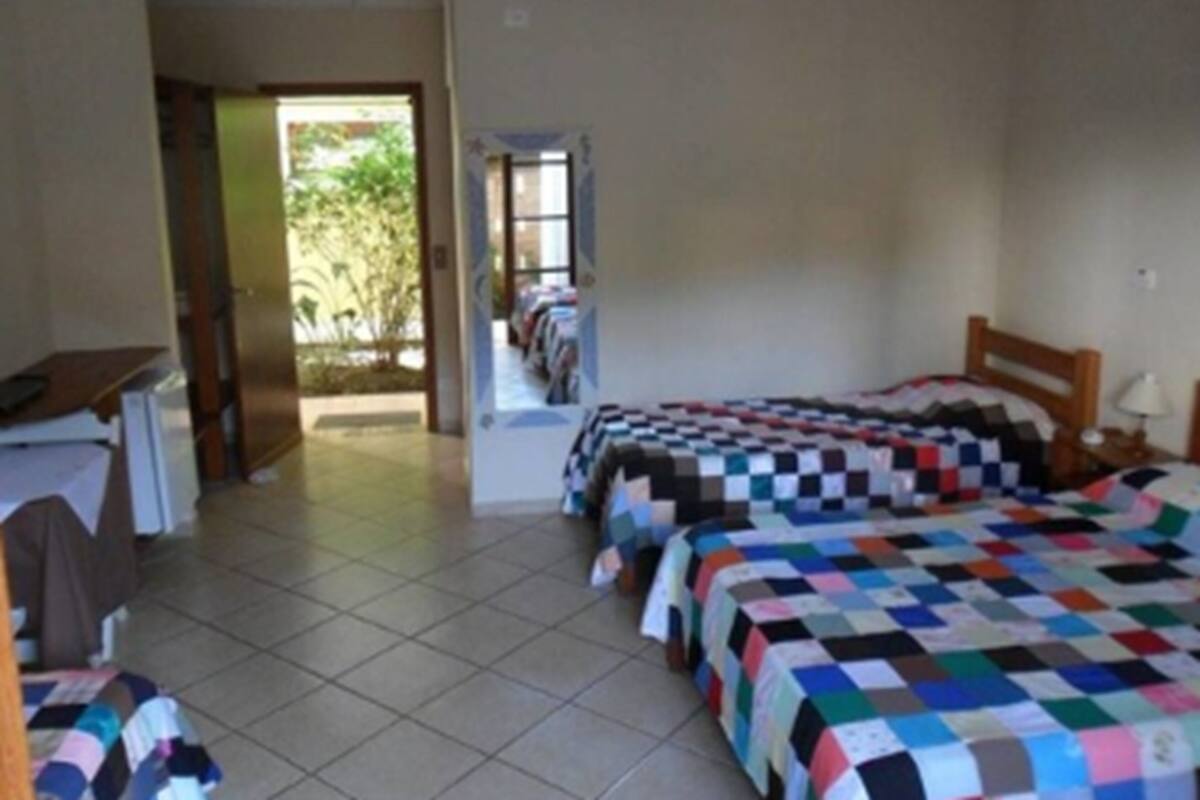 A bedroom with two beds, a desk, and a chair.