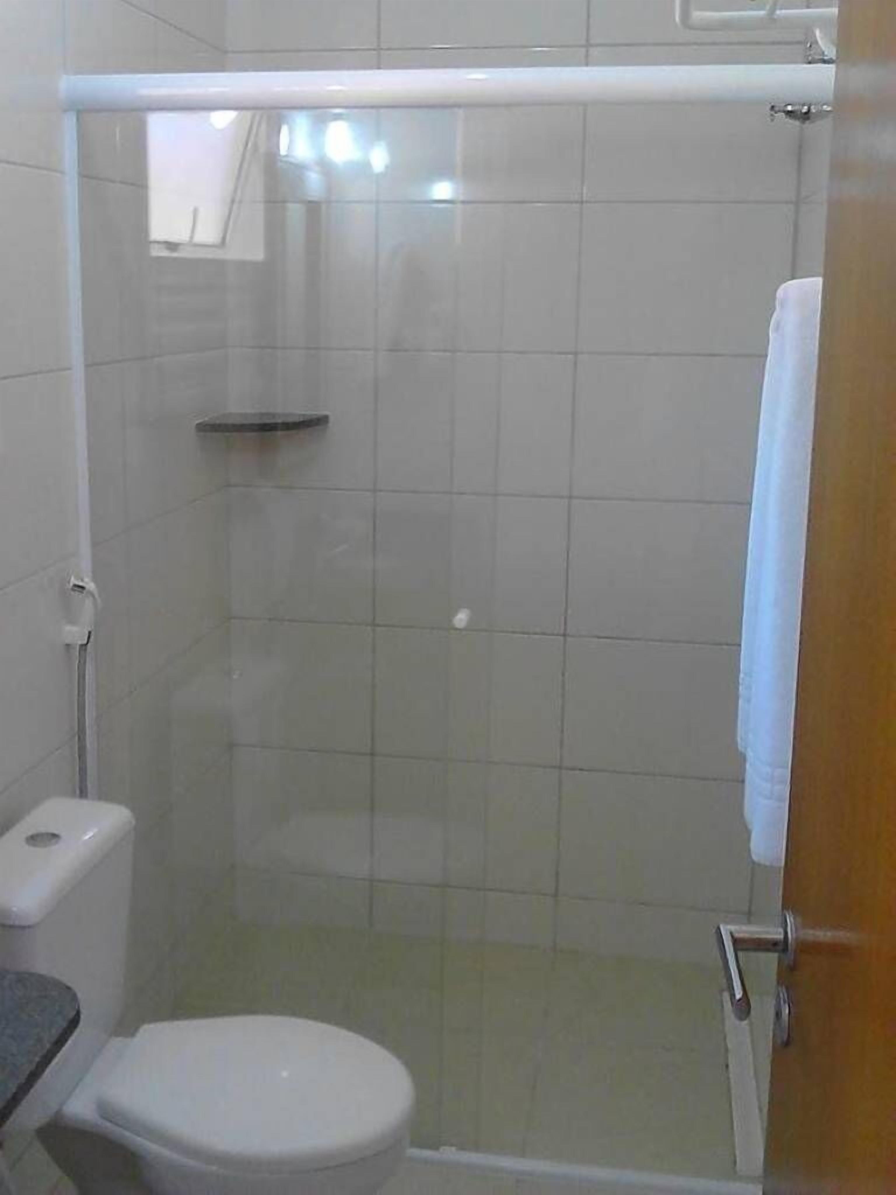 A bathroom with a shower, toilet, and sink.