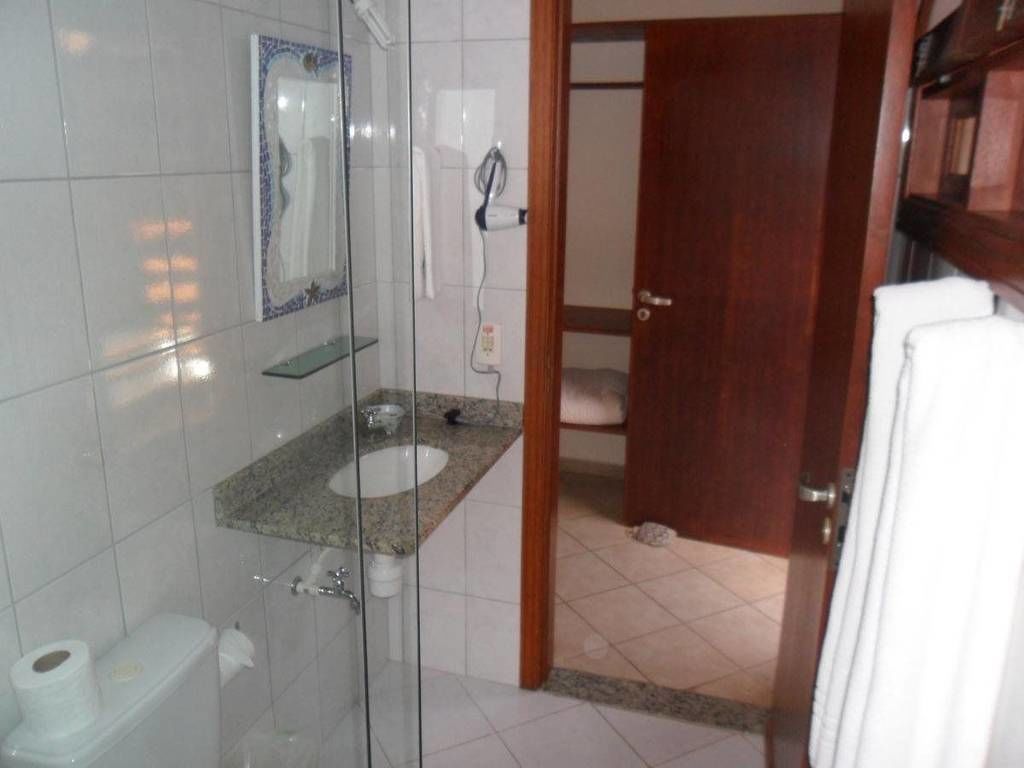 Une salle de bain avec une douche à parois de verre, un lavabo avec un plan de toilette en granit et des toilettes.