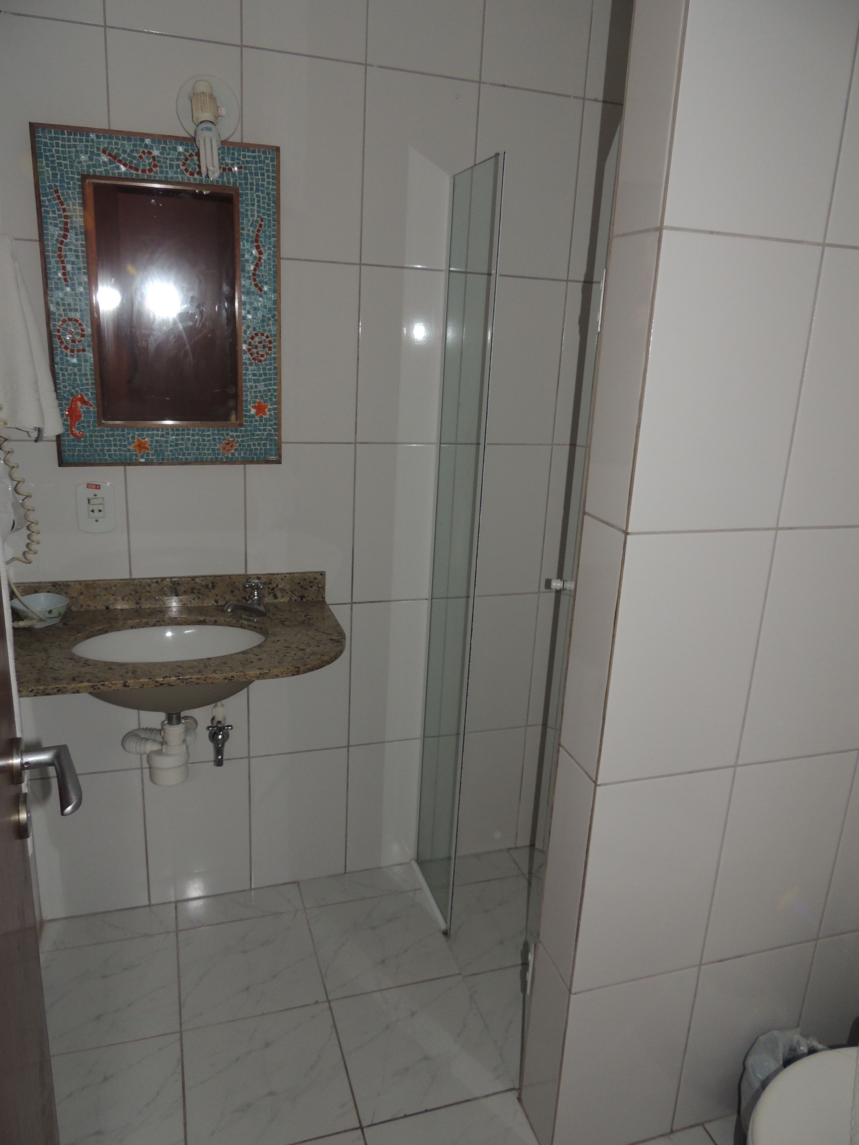 Une salle de bain avec un lavabo, un miroir et une douche.