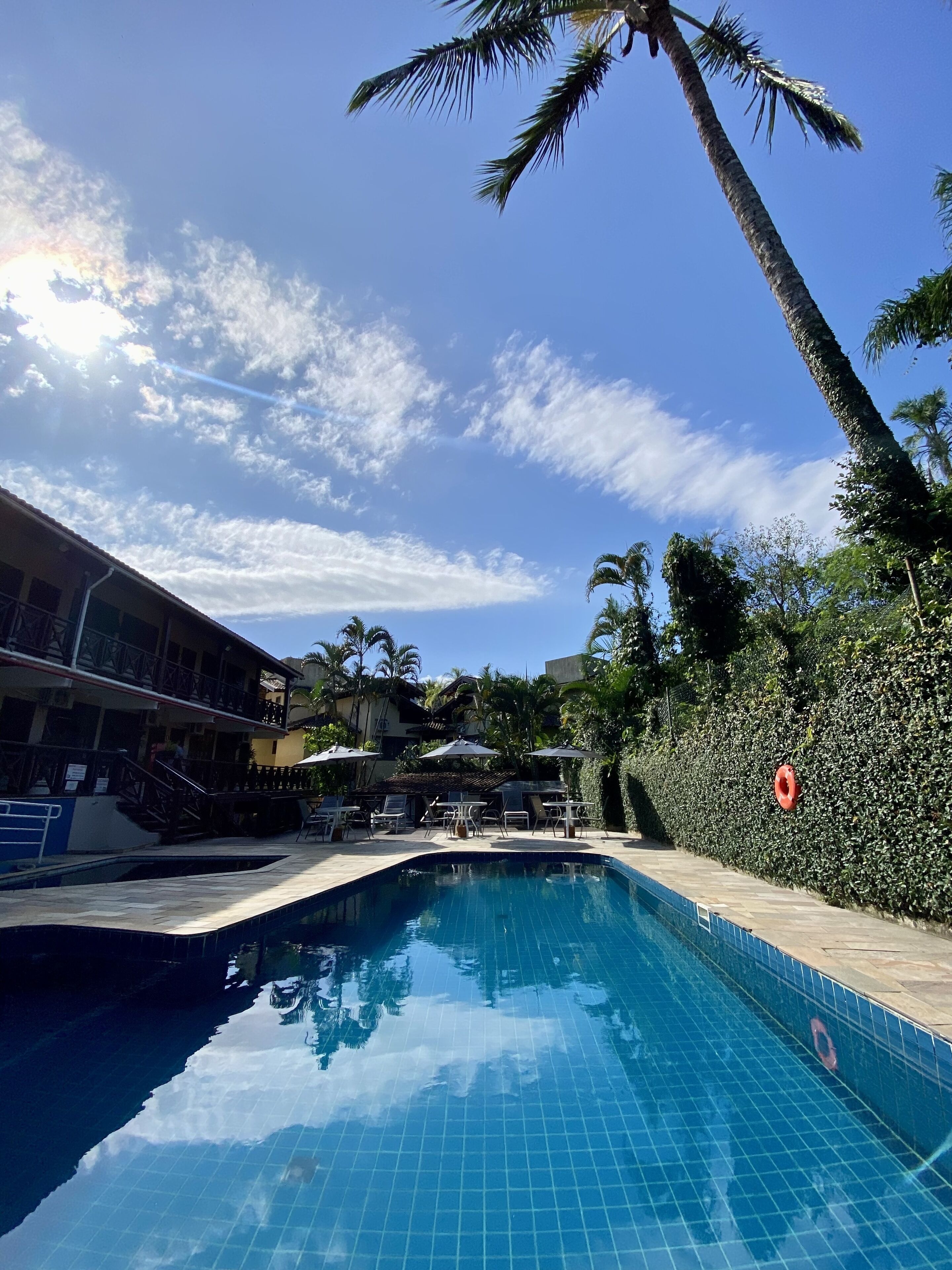 Una piscina al aire libre, sombrillas, tumbonas